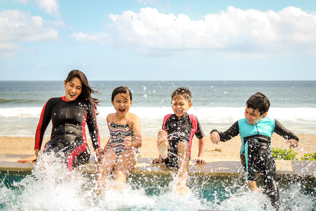 gallery-6 A family having fun splashing water near the seashore on a sunny day in Bali, Indonesia.