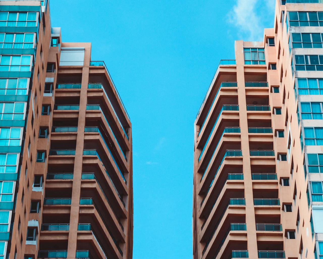 why-choose-us Contemporary high-rise buildings contrasted against a vivid blue sky, showcasing modern urban architecture.