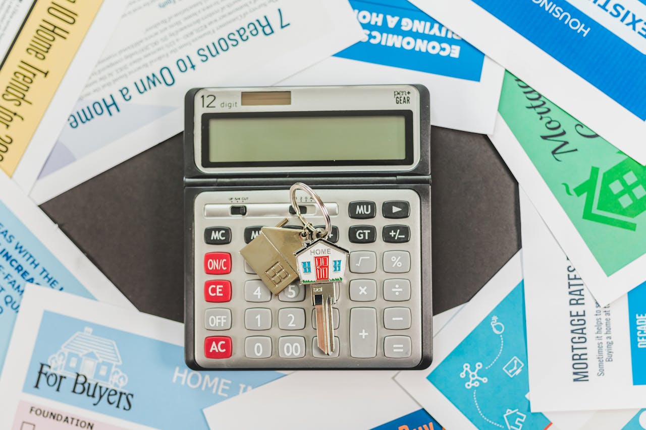 hero-img-02 Calculator with keys and real estate documents symbolizes home buying finances.